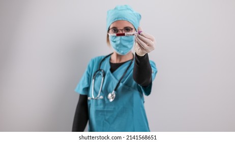 Female Doctor Examines A Blood Sample For The Corona Virus - Studio Photography