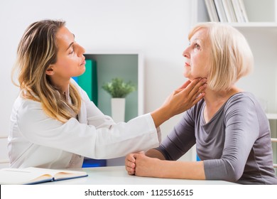 Female doctor examines her senior patient's throat in office. - Powered by Shutterstock