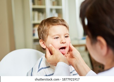 Female doctor examines throat and tongue in child with tonsillitis or sore throat