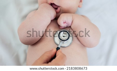 Female doctor examining baby boy toddler listening to lungs with stethoscope. A nurse having medical checkup with sick little newborn patient in clinic. Pediatrician's appointment, healthcare concept
