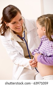 Female Doctor Examining Child With Stethoscope At Medical Office