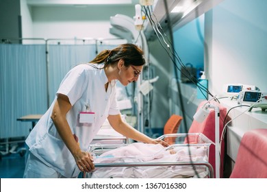 Female Doctor Examining Newborn Baby In The Hospital. Night Shift