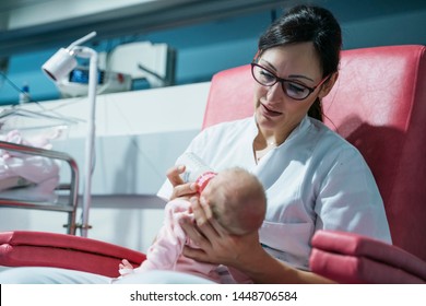 Female Doctor Examining Newborn Baby After Lunch. Night Shift