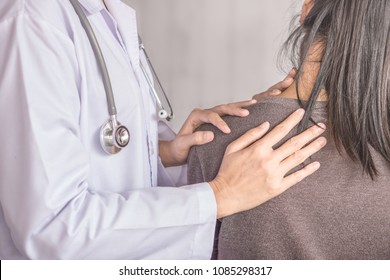 female doctor examining a patient suffering from neck and shoulder pain  - Powered by Shutterstock