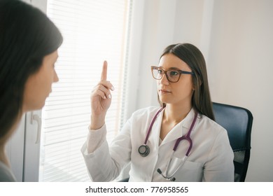 Female Doctor Examining A Patient's Eye Reflex And Accommodation. Medical Examination, Clinic, Hospital 