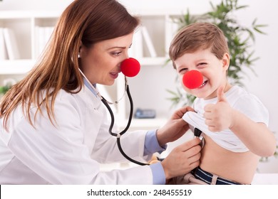 Female Doctor Examining Success Child With Finger Up