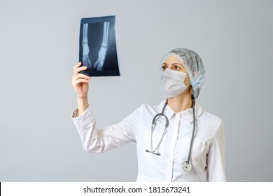Female doctor examining x-ray image of legs of newborn baby