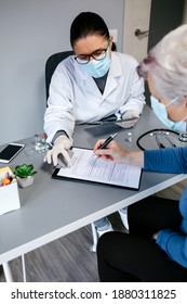 Female Doctor Explaining To Her Patient The Consent Form To Coronavirus Vaccine