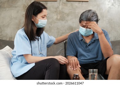 Female Doctor With Face Mask Checking Health Of Asian Elderly Male Patient At Home As A Medical Service For Visiting Sick Older People After Retirement And Caregiver From Professional