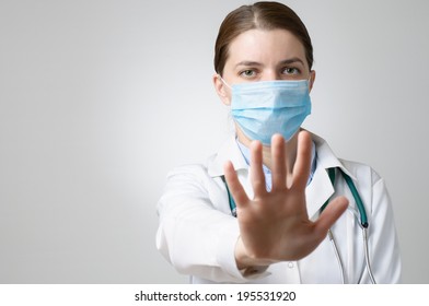 Female Doctor In Face Mask Showing Stop Sign With Her Hand