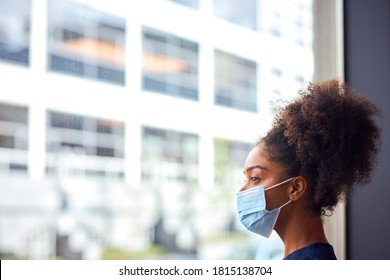 Female Doctor In Face Mask Wearing Scrubs Under Pressure In Busy Hospital During Health Pandemic