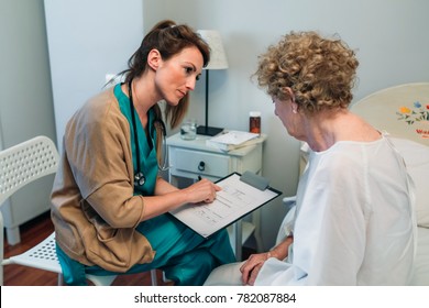 Female doctor filling out a questionnaire to a senior patient - Shutterstock ID 782087884