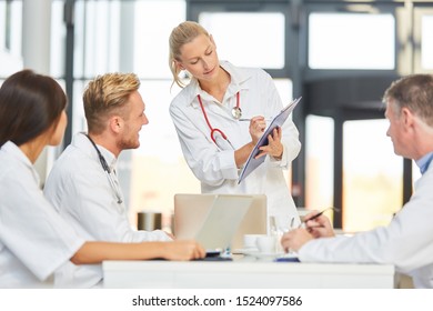 Female doctor gives a speech in the meeting and explains the project planning with clipboard - Shutterstock ID 1524097586