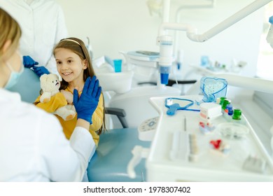 Female Doctor Is Giving Hi Five To Little Girl After A Successful Dental Examination.