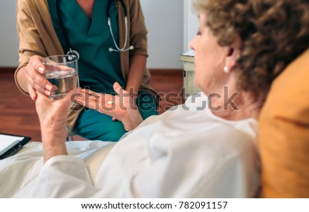 Similar – Female doctor giving medication to elderly patient