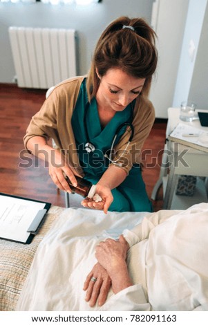 Female doctor giving medication to elderly patient