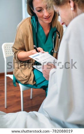 Doctor giving a prescription to senior patient