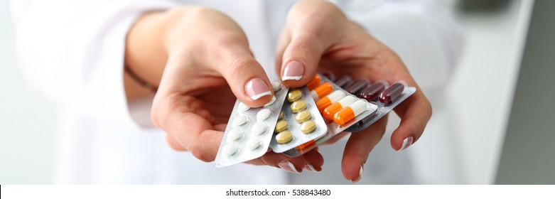 Female doctor hand hold pack of different tablet blisters at workplace. Panacea, life save service, prescribe medicament, legal drug store, disease healing, blood pressure concept. Letterbox view