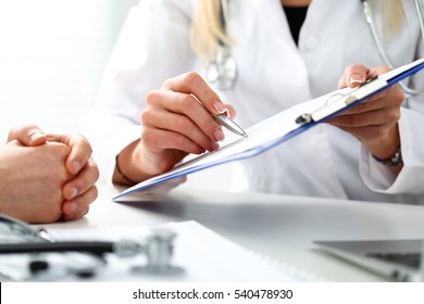 Female doctor hand hold silver pen filling patient history list at clipboard pad. Physical, exam, er, disease prevention, ward round, visit check, 911, prescribe remedy, healthy lifestyle concept - Shutterstock ID 540478930