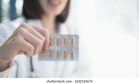 Female Doctor Hand Holding Pack Of  Tablet Blisters At Workplace Closeup. Legal Drug Store, Disease Healing