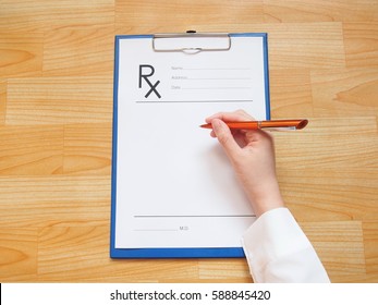 Female doctor hand writing prescription or rx form to patient at hospital or clinic. Healthcare and medical concept.