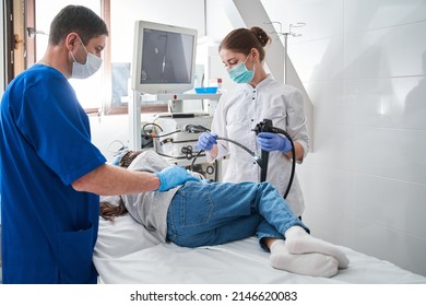 Female doctor holding endoscope while making gastroscopy for the little girl