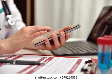 Female Doctor Holding Mobile Smart Phone. Close Up