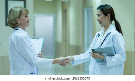 Female Doctor Holding A Patient's Profile And Shaking Hands Is In The Hospital.