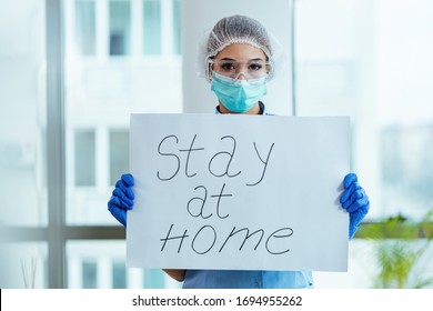 Female Doctor Holding Placard With Stay At Home Message As Appeal For Social Distancing During A Coronavirus Epidemic.