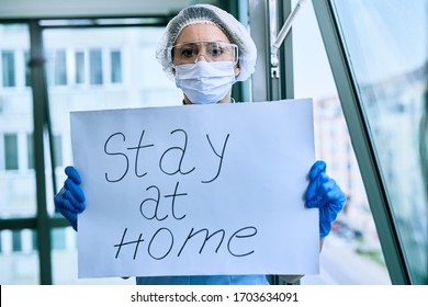 Female Doctor Holding Placard With Stay At Home Text As Appeal During COVID-19 Epidemic. 