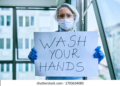 Female Doctor Holding Placard With Wash Your Hands Text As Appeal During Coronavirus Pandemic. 