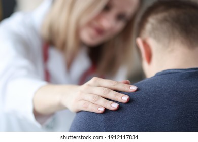 Female Doctor Holding Shoulder Of Male Patient Closeup. Psychological Support Concept