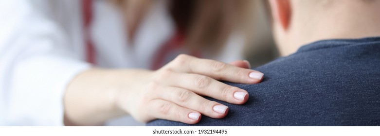 Female Doctor Holding Shoulder Of Male Patient Closeup. Psychological Support Concept