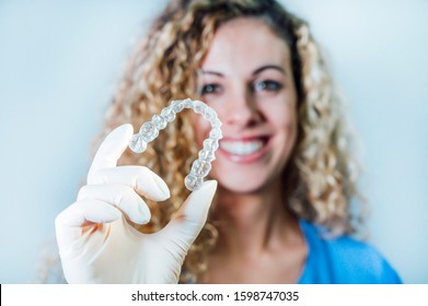 Female doctor holding a transparent dental aligner
