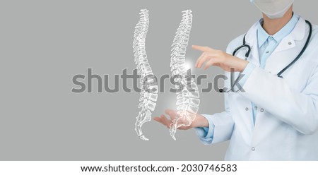 Female doctor holding virtual Spine in hand. Handrawn human organ, copy space on right side, raw photo colors. Healthcare hospital service concept stock photo