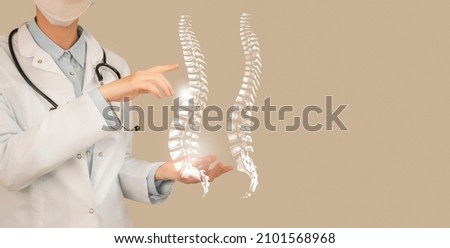 Female doctor holding virtual Spine in hand. Handrawn human organ, copy space on right side, beige color. Healthcare hospital service concept stock photo
