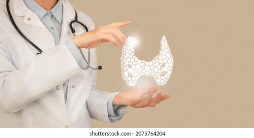 Female doctor holding virtual Thyroid Gland in hand. Handrawn human organ, copy space on right side, beige color. Healthcare hospital service concept stock photo