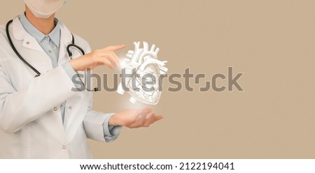 Female doctor holding virtual volumetric drawing of heart in hand. Handrawn human organ, copy space on right side, beige color. Healthcare hospital service concept stock photo