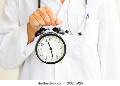 Female Doctor Holds Clock On Her Hand