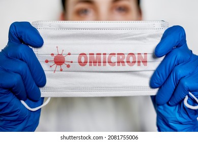 Female doctor holds a face mask with - Omicron variant text on it. Covid-19 new variant - Omicron. Omicron variant of coronavirus. SARS-CoV-2 variant of concern - Shutterstock ID 2081755006