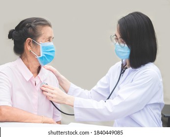 Female doctor in hospital use stethoscope listen to senior woman heart, do medical checkup. wearing medical mask to protect from spreading virus, healthcare Treatment An Elderly Person concept - Powered by Shutterstock