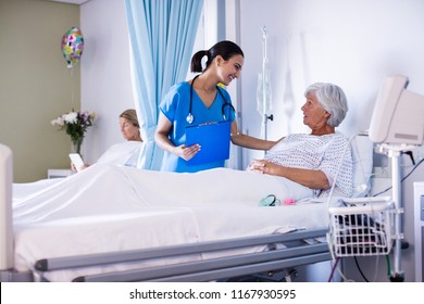 Female doctor interacting with female senior patient in the ward at hospital. Healthcare workers in the Coronavirus Covid19 pandemic - Powered by Shutterstock