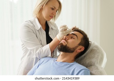 Female Doctor And Male Client During Filler Injections In Aesthetic Medical Clinic