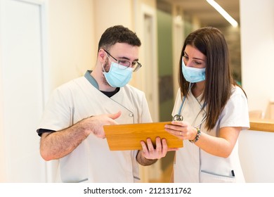 Female Doctor And Male Nurse Talking And Sharing Information At The Reception Of The Health Center.