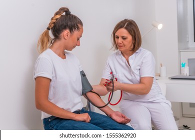 Female Doctor Measuring The Blood Pressure Of Her Young Teen Patient. Nurse Measuring Blood Pressure.