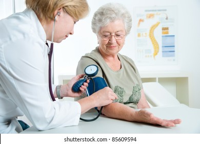 Female Doctor Measuring Blood Pressure Of Senior Woman