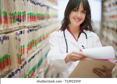 Female Doctor With Medical File Smiling