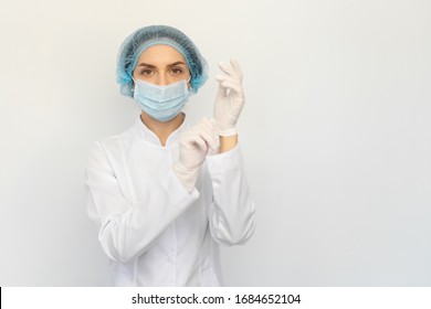 A Female Doctor In A Medical Mask Puts White Rubber Gloves