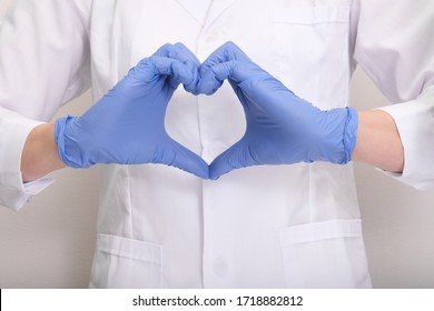 A Female Doctor Or Nurse In Blue Protective Gloves Making Heart Shape Symbol With Hands, Therapy, Treatment And Insurance Concept.