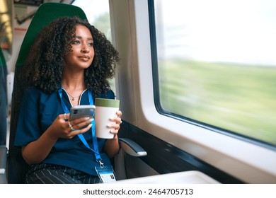 Female Doctor Or Nurse Commuting On Train With Mobile Phone And Reusable Coffee Cup - Powered by Shutterstock